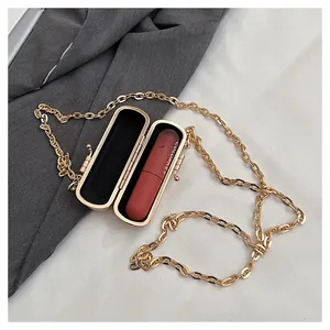 Detailed macro view of an elegant mini metal lipstick bag with a gold chain strap