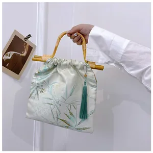 Dettaglio borsa in stile cinese con manico in bambù e nappa verde di tendenza
