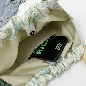 Dettaglio interno di una borsa a tracolla floreale con tasca interna e capienza.