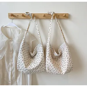 Elegante bolso de hombro hobo con estampado floral para mujer colgado en soporte