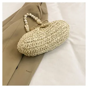 Borsa in paglia beige con manico in perline e catena dorata, dettaglio