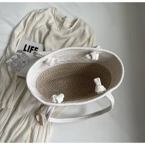 Vue de dessus d'un cabas en paille tissée avec anses nouées et texture interne