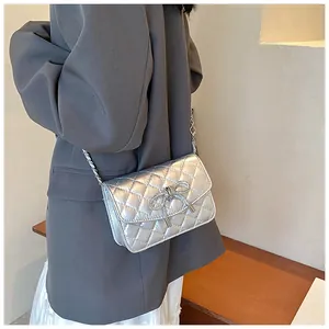 Zilveren gewatteerde crossbodytas met fonkelend strikje en elegante kettingsluiting.