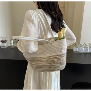 Détail d'un sac cabas en paille fait main avec motifs tressés et tulipes jaunes.