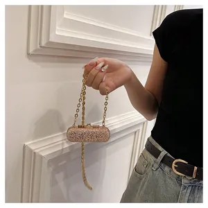 Detailed shot of a sparkling gold sequin mini lipstick bag held in hand for parties