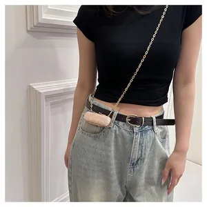 Close-up view of a model wearing a mini rose gold sequin lipstick bag with gold chain