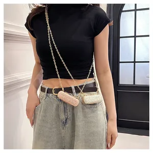Detail view of stylish mini glitter lipstick bags with gold chain straps worn by model