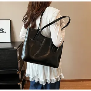 Stylish glossy black large capacity underarm tote bag for women shown on shoulder