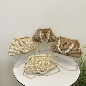 Eleganti pochette in paglia intrecciata con manici in perle e marmo per la spiaggia
