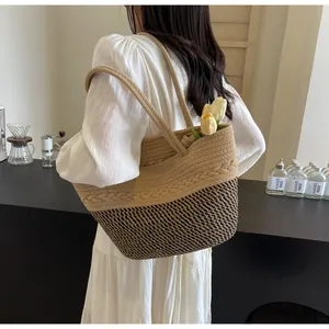 Vue détaillée du sac cabas bicolore en paille tressée avec un ornement de tresse