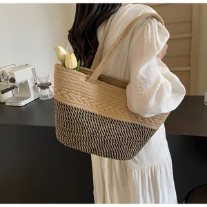 Vue détaillée d'un sac cabas en paille tissée avec motif bicolore et anses en corde