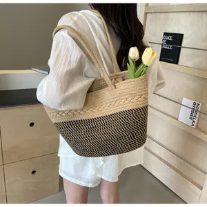 Sac cabas en paille tissé à la main avec motif noir, idéal pour un style de vacances.