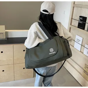 Large capacity army green travel duffel bag with shoulder strap carried by a model