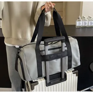 Large grey travel duffel bag with a functional trolley sleeve shown on a white suitcase