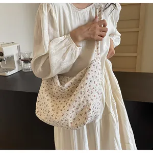 Vista detallada de un bolso bandolera de tela con estampado floral vintage en modelo con vestido