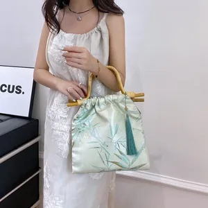 Elegant New Chinese style floral handbag with bamboo handle and green silk tassel.