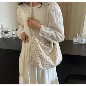 Vista detallada de un bolso tote con estampado floral vintage usado como bandolera.