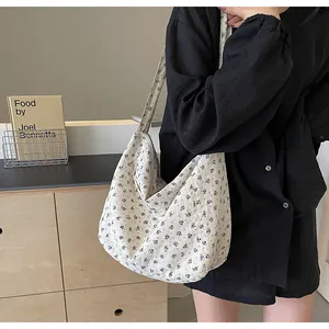 Vista detallada del bolso hobo de flores para mujer llevado por una modelo.