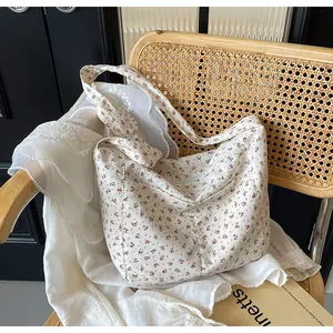 Primer plano del delicado estampado floral rojo y la tela suave de este bolso tote