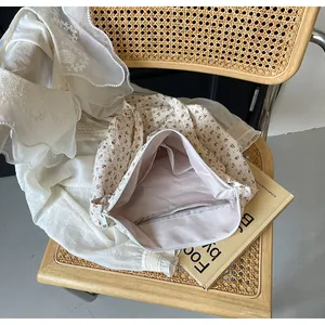 Detalle del bolso tote floral que muestra el forro interior rosa y bolsillo con cremallera.