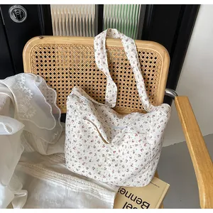 Detalle de bolso tote con estampado de flores sobre una silla de mimbre rústica chic