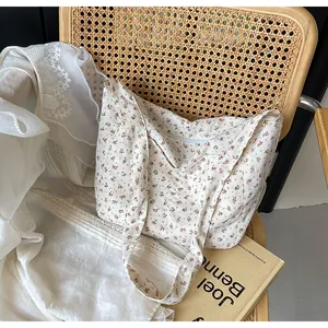 Detalle de un bolso tote de flores en una silla de mimbre vintage con encaje
