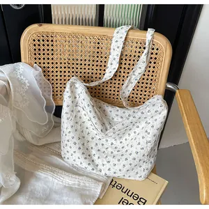 Bolso tote de lona con flores azules en una silla de mimbre rústica con encaje blanco