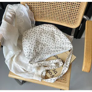 Vista detallada de un bolso bandolera floral para mujer sobre una silla de mimbre