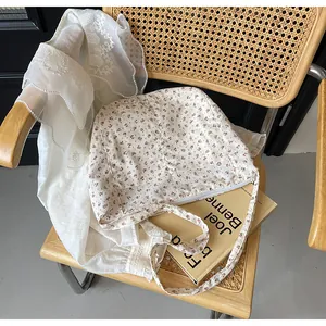 Bolso tote de lona con flores sobre una silla vintage con detalles de encaje blanco