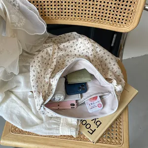 Bolso hobo con estampado floral que muestra un interior espacioso con artículos