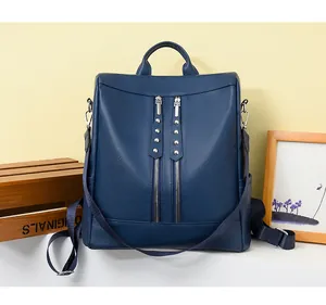 Vista dettagliata di un elegante zaino in pelle blu scuro con borchie decorative metalliche