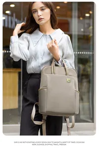 Close-up detail of a minimalist taupe square backpack being carried by a fashion model