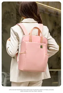 Close-up of a stylish pink travel backpack worn by a model in a professional setting