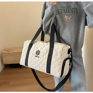 White quilted travel duffel bag shown as a crossbody gym and weekend luggage bag