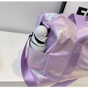 Detailansicht der schillernden Reisetasche mit Seitentasche und gefaltetem Regenschirm.