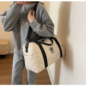 Detailed view of cream quilted duffle bag featuring black straps and NINGJIA branding