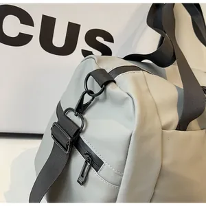 Close-up of durable black metal hook and zipper detail on grey nylon travel duffle bag