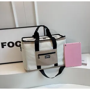 Vista dettagliata di una grande borsa da viaggio crema con tablet rosa per la misura