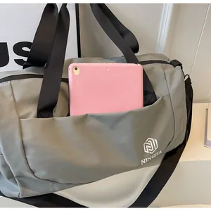Detail of gray large capacity travel duffel bag with a front pocket for tablet