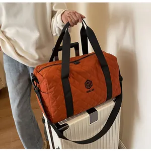 Detail of orange quilted travel bag on a suitcase, perfect for gym or weekend trips.