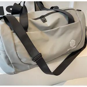 Detailed view of a grey large capacity travel bag with durable black straps and logo.