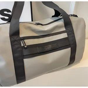 Close-up of a grey large capacity travel bag with durable black straps and zipper details