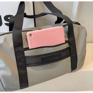 Detail view of grey travel bag with a pink tablet inside the front zipper pocket.