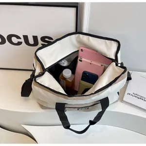 Vista interna di una borsa da viaggio crema capiente con tablet e oggetti personali.
