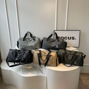 Five multi-colored large capacity travel duffel bags displayed on a modern white stand
