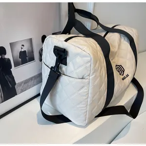 Large white quilted travel duffel bag with black shoulder straps and brand logo detail