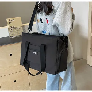 Vista dettagliata della grande borsa da viaggio nera indossata a tracolla da una modella