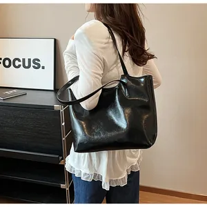 High-gloss black tote bag for women featuring a minimalist and spacious design for daily use