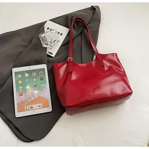 Red large capacity underarm tote bag styled with a professional blazer and tablet PC.