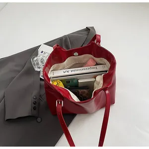 Interior view of a red leather tote bag showing its large storage capacity with items.